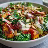 Hearty Kale Salad Bowl arranged in a white bowl with cherry tomatoes, almonds, and pumpkin seeds, ready to enjoy.