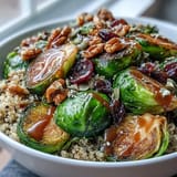 Golden roasted Brussels sprouts and onions sizzle on a sheet pan, ready for the Roasted Brussels Sprouts Bowl.