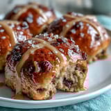Soft and fluffy hot cross buns with orange glaze, featuring cinnamon, nutmeg, and a fragrant citrus topping for a festive treat.  