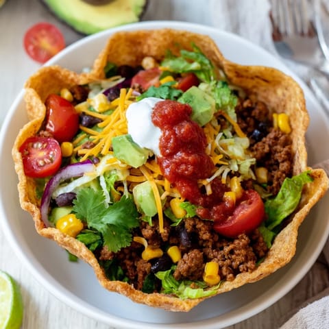 This image shows a beautifully arranged taco salad ready to eat, with all the delicious components.
