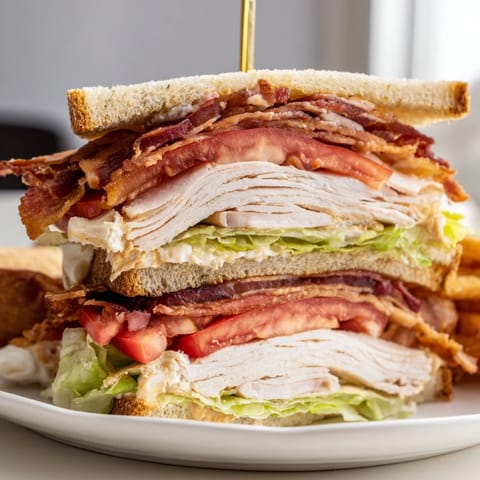 Golden-brown toasted bread cradles delicious Turkey Club Sandwich fillings, a classic American meal.