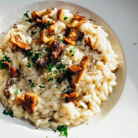 Hearty vegetarian roasted mushroom risotto topped with melted Parmesan cheese and thyme, ready to serve for dinner.  