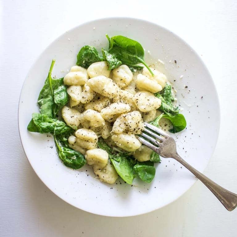 A comforting skillet of Creamy Garlic Gnocchi with golden-brown edges, fresh spinach, and grated Parmesan, ideal for an easy vegetarian dinner.  