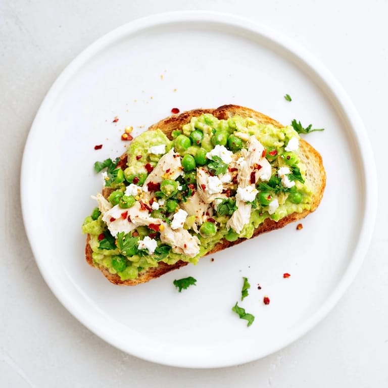 Open-faced Smashed Pea & Chicken Toast served warm with lemon wedges and a glass of crisp white wine.