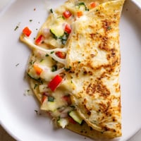 Golden-brown quesadillas filled with melted cheese, chicken, and colorful bell peppers, ready to eat.